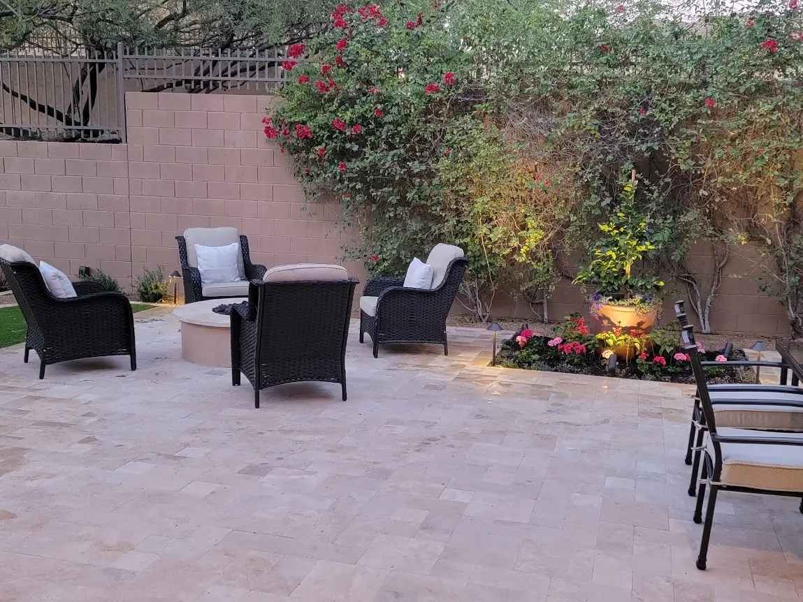 Finished travertine paver patio with a seating area, firepit table, and flowering bougainvillea